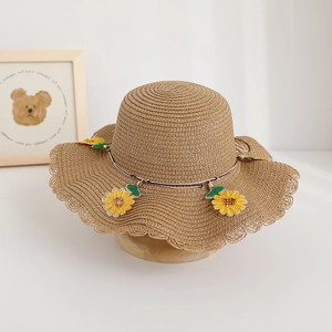 Dettaglio cappello di paglia per bambini con tesa ondulata e ricamo di girasole fine