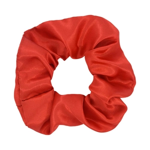 Detailed view of a red satin oversized scrunchie showing glossy fabric texture and pleats