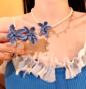 Close-up of blue beaded floral jewelry set featuring elegant pearl drops and silver chains