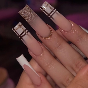 Close-up of coffin fake nails with champagne gold glitter and classic plaid patterns