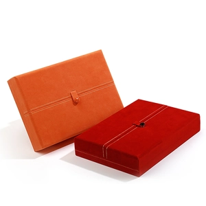 Detail view of red and orange velvet jewelry boxes with elegant snap button closures