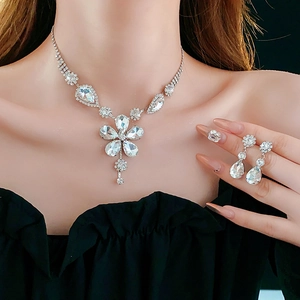 Silver flower and teardrop crystal jewelry set worn by a model in a close-up detail shot