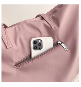 Detail of pink nylon tote showing a hidden anti-theft back pocket for mobile phone storage