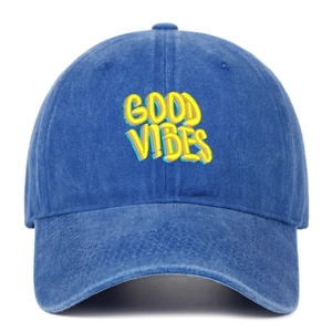 Close-up of yellow 3D GOOD VIBES embroidery on washed blue cotton baseball cap