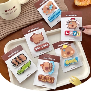 Detailed view of Capybara acrylic hair clips in warm brown and beige tones