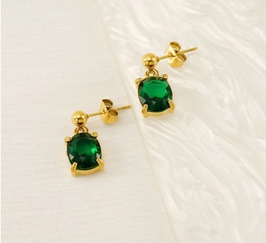 Detailed close-up of oval green zircon earrings in gold-plated stainless steel settings