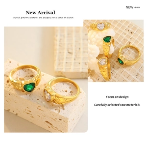Detailed close-up of golden rings featuring heart-cut emerald and white gemstones