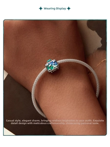 Close-up of woven mesh bracelet with a blue enamel star and moon night sky pendant