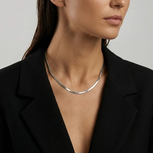 Close-up of a silver titanium steel snake bone necklace worn on a female model