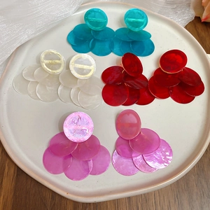 Detailed display of colorful layered round resin earrings in a ceramic tray