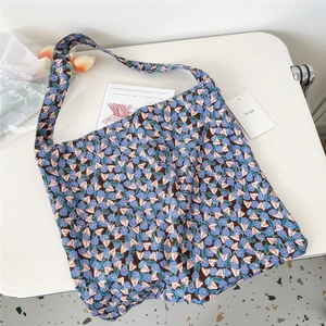 Detail of floral corduroy tote bag with blue patterns on dark fabric and soft texture