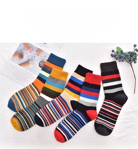 Flat lay of colorful striped cotton crew socks with vibrant geometric patterns for men