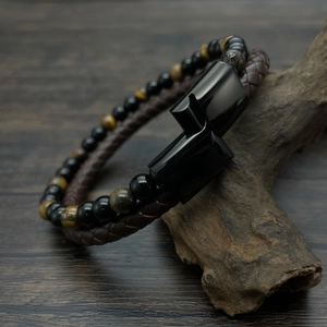 Close-up of double-layer hand-woven leather bracelet with tiger eye beads on wood