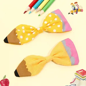 Handmade pencil-shaped bow hair clips with yellow polka dots for back-to-school season
