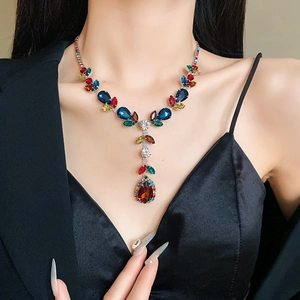 Close-up of elegant leaf-shaped necklace featuring colorful zircon stones on a model
