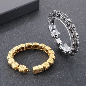 Detail of punk style skull link bracelets in gold and antique silver stainless steel
