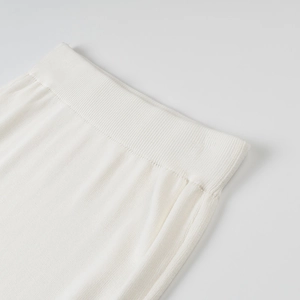 Detail shot of the elastic ribbed waistband on a cream white knitted elegant skirt set