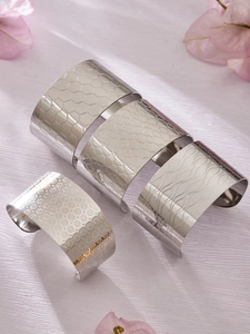 Vue détaillée de quatre bracelets manchettes en acier inoxydable argenté avec textures
