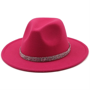 Détail d'un chapeau fedora fuchsia à large bord avec une bande de paillettes étincelantes