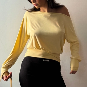 Detail of cream long sleeve off-shoulder top showing soft knit fabric and slim fit design