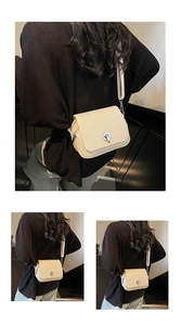 Detail view of beige crossbody bag with woven texture, metal twist lock and dual zippers