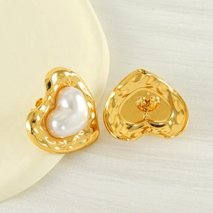 Detailed view of hammered gold heart earrings with pearl inlay and butterfly backings