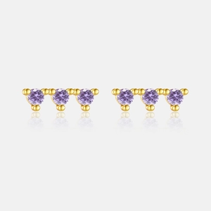 Close-up of gold s925 silver stud earrings with three round purple zircon stones