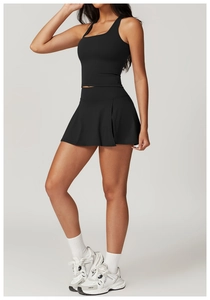 Detail van zwarte yoga-top en geplooide tennisrok gemaakt van rekbare sportstof