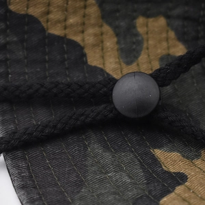 Close-up of camouflage bucket hat showing adjustable drawstring toggle and twill fabric