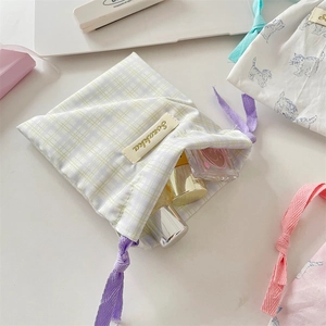 Close-up of fabric drawstring pouches with cat and plaid prints for makeup storage