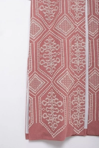 Close-up of pink long-sleeve cardigan featuring intricate white geometric embroidery detail