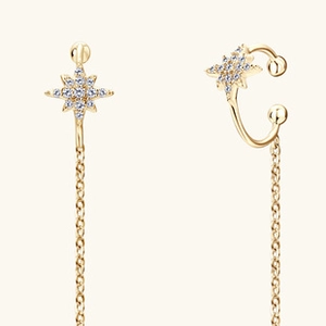 Detail of gold star earrings with cubic zirconia and long chain tassels