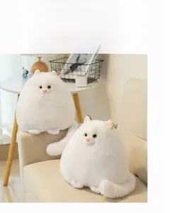 Detail of two fluffy white Persian cat plush toys with soft fur on a cozy sofa