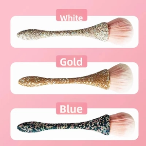 Detailed view of rhinestone-encrusted makeup brushes in white, gold, and blue colors