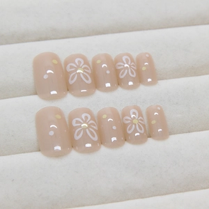 Sweet nude press-on nails with white flower and yellow polka dot patterns