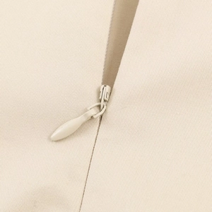 Macro detail of high-quality invisible zipper on beige twill fabric midi dress