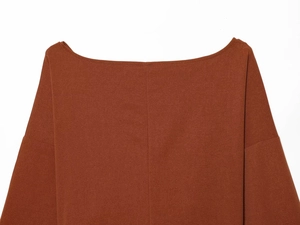 Detail of off-shoulder neckline on brown long sleeve top with fine textured fabric