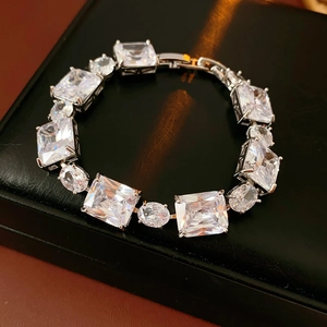 Detail view of silver zircon bracelet with square and oval stones on black leather