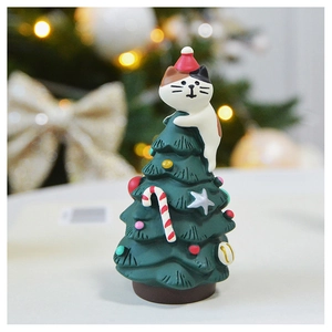 Miniature resin Christmas tree with cute cat figurines on a cozy festive tabletop