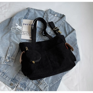 Detail of black corduroy tote bag with matching coin purse on a blue denim jacket