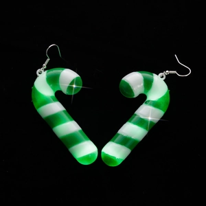 Macro view of Christmas candy cane earrings in green and white stripes forming a heart shape