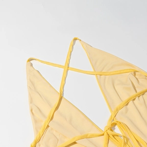 Detail of sexy yellow open back dress showing delicate crisscross lace-up straps