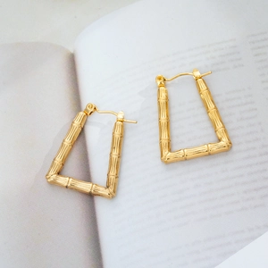 Macro view of geometric 18K gold-plated titanium steel earrings with bamboo texture
