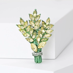 Detailed close-up of emerald green enamel floral brooch with sparkling marquise crystals