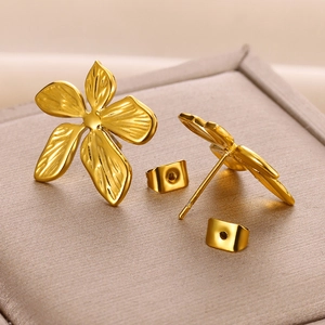 Elegant gold flower stud earrings with detailed petal textures on jewelry box