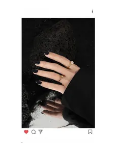 Macro view of minimalist gold knot ring and crystal stone ring on dark volcanic rock