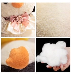 Detail of penguin plush toy showing soft white faux fur and a pink satin bow with pearl buckle