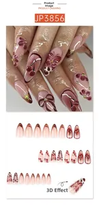 Detail of 3D almond press-on nails with red-brown flower, bow, and cherry motifs
