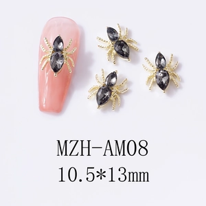 Macro shot of 10.5x13mm spider nail charm with gold metal frame and faceted gemstones