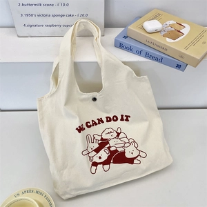 Détail du sac cabas en toile avec imprimés animaux mignons et bouton pression en métal